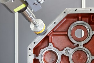 Schwere Getriebegehäuseteile effektiv automatisiert: Das Kardangelenk des Roboters sorgt für die nötige Beweglichkeit in allen Achsen und stellt sicher, dass das Werkzeug an alle Kanten heran- und in alle Bohrungen hineinkommt. 